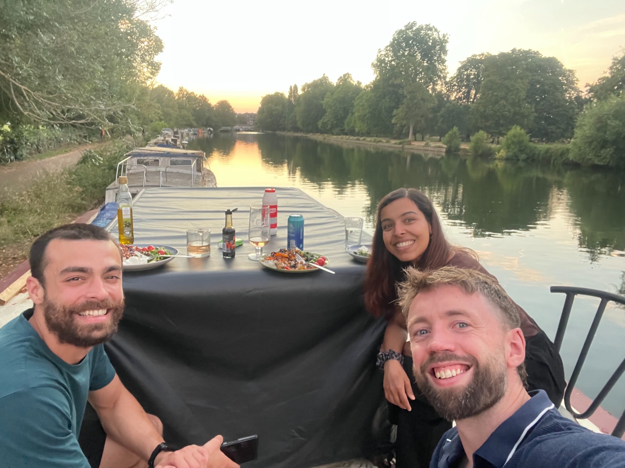 CANN lab members sharing dinner together on a boat at sunset.